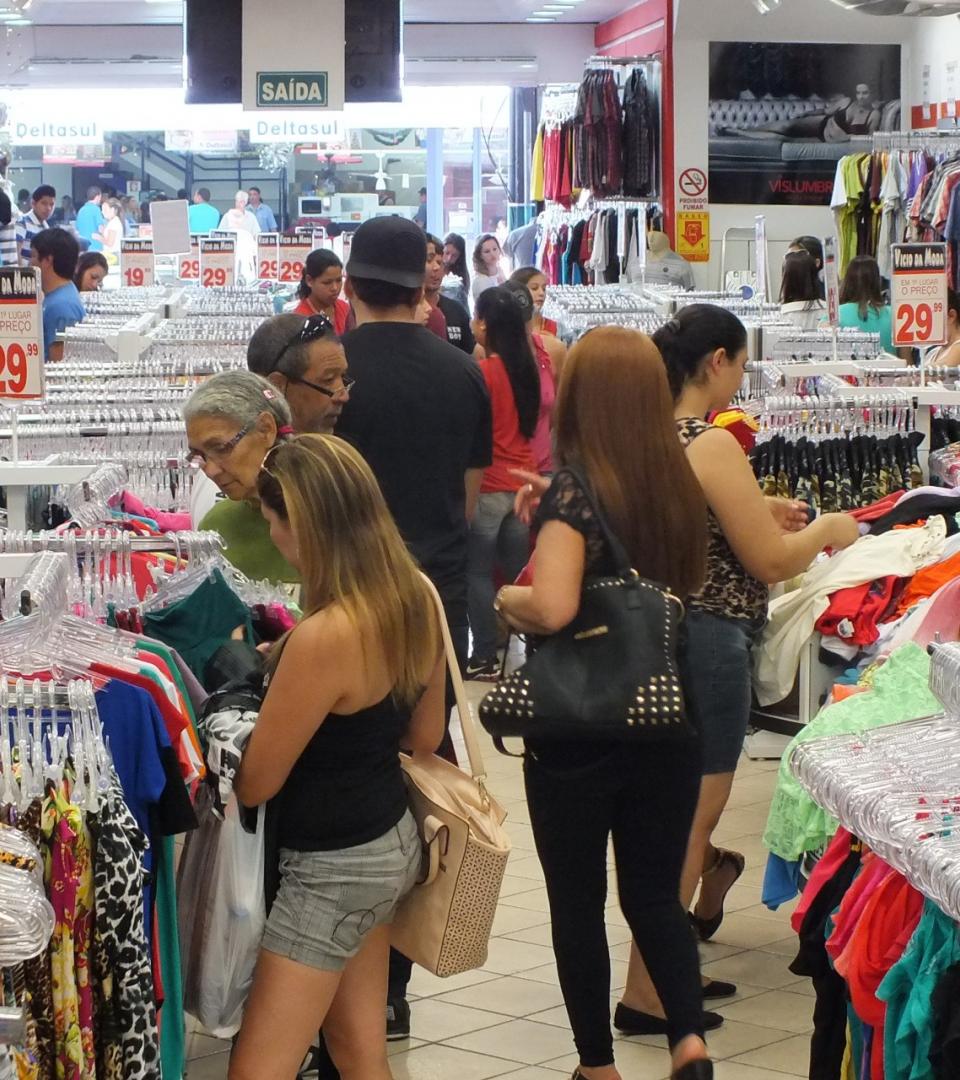 varias pessoas a escolher roupa numa loja de venda de material , neste caso roupa de vestir