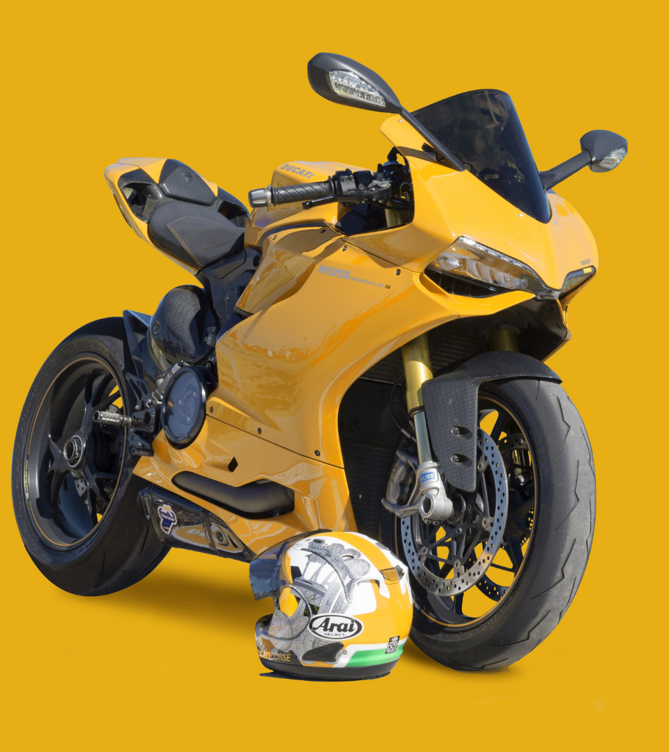 uma moto amarela e um capacete no chao