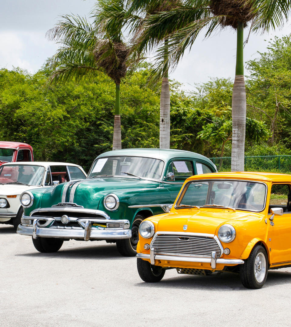 varias viatura, uma amarela outra verde e outra cinza , todas classicas